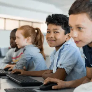 Børn der sidder i en klasse foran en computer
