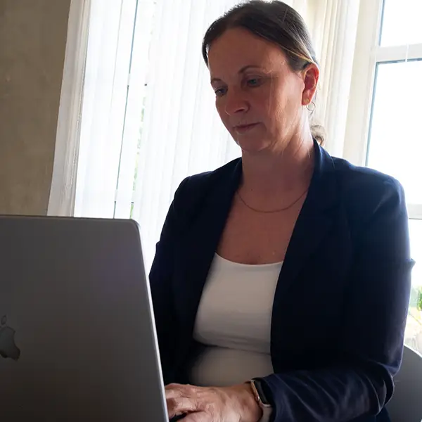 Trine arbejder foran en ccomputer