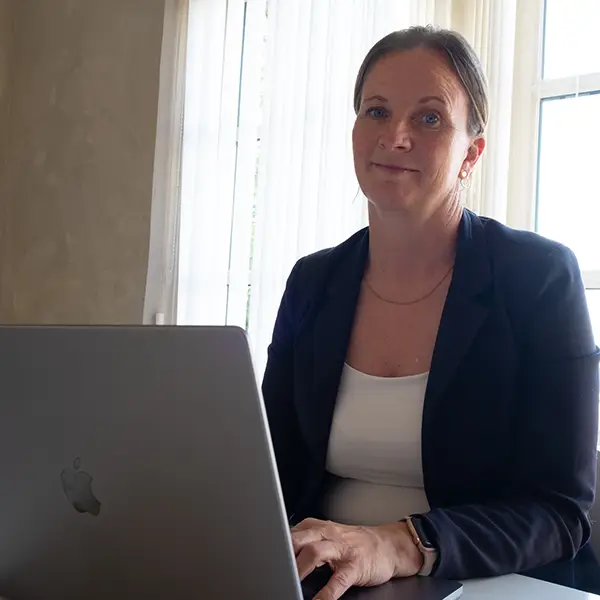 Trine sidder og arbejder foran en computer